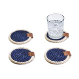 Set of four blue and white rope coasters with brown leather accents on a white background.