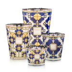 A collection of four Baobab scented candles in various sizes, featuring a vintage 24-carat gold and midnight blue print with a four-leaf clover design.