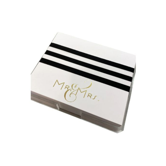 An 8.5 x 7 inch notepad with gold foil detailing and the text 'Mr. & Mrs.' on the cover, presented in a clear acrylic tray.