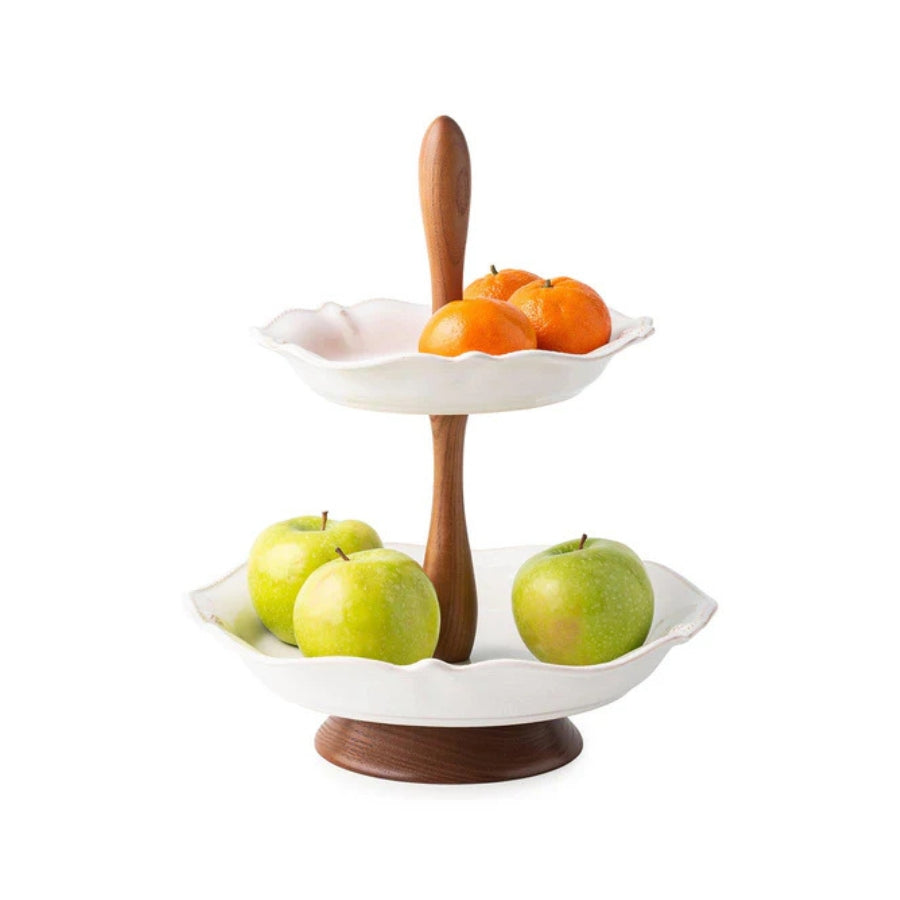 Two-tiered fruit bowl with apples and oranges on a white background