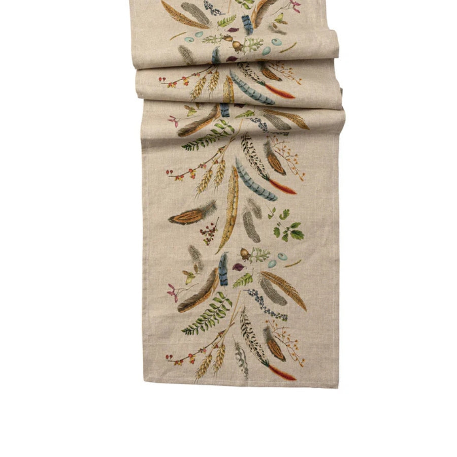 Decorative fall/autumn table runner with embroidered feather pattern on a white background