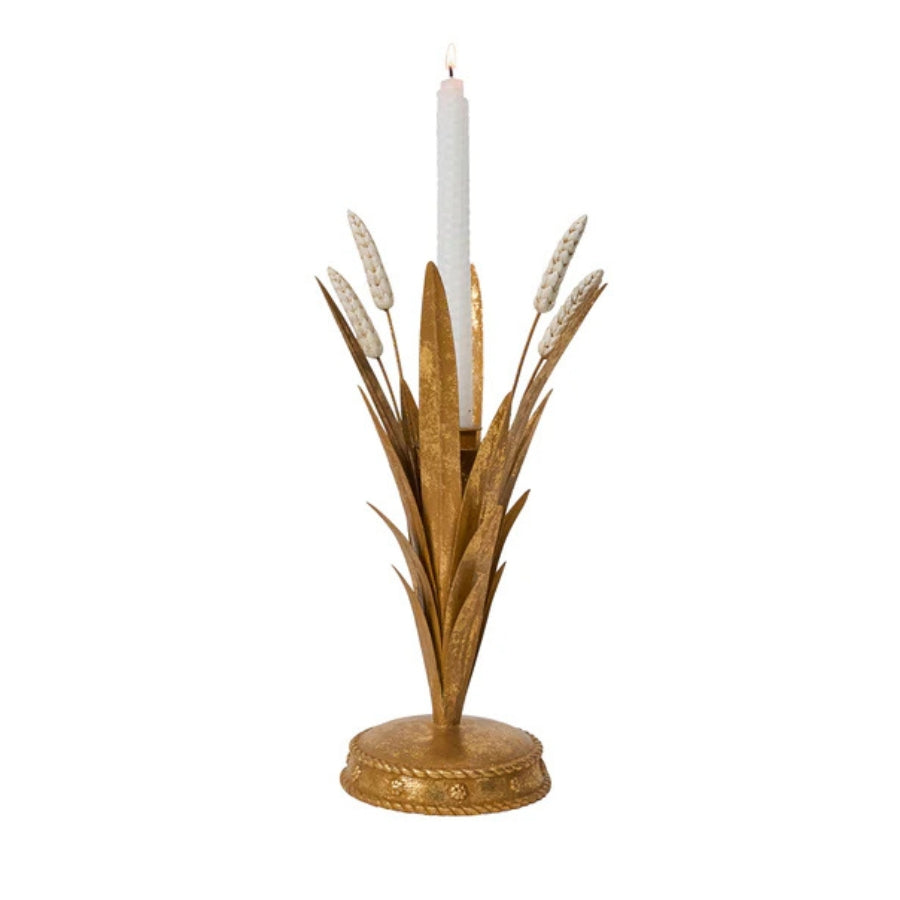 Decorative candle holder with gold leaves and a white candle on a white background