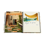 Open book showing a scenic illustration of Lake Como with outdoor furniture.