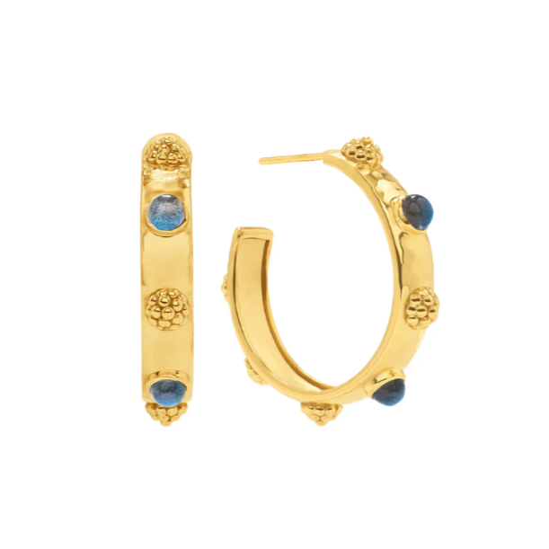 Gold hoop earrings with blue gemstones on a white background