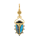 Gold beetle-shaped earring with blue stone on a white background